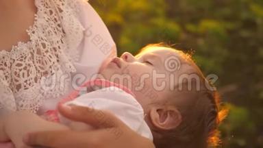 日落时分，一个小婴儿睡在母亲的怀里，慢镜头拍摄